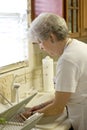 Retiree Washing Dishes In Kitchesn