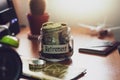 Retirement budget concept. Money for retirement savings in a glass jar on working desk. Royalty Free Stock Photo