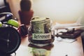 Retirement budget concept. Money for retirement savings in a glass jar on working desk. Royalty Free Stock Photo