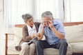 Retirement couples take care of each other when they are sick, sitting on the couch in the house without the children to look Royalty Free Stock Photo