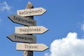 Retirement, enjoyment, happiness, freedom, travel - wooden signpost with five arrows