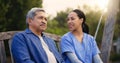 Retirement, old man and nurse on a bench in the park together for nostalgia or thinking of a memory. Summer, healthcare Royalty Free Stock Photo