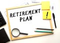 RETIREMENT PLAN text is written on a white office board. Work table with office supplies Royalty Free Stock Photo