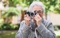 Retirement, relax and elderly woman with photographer hobby to enjoy pension leisure in garden. Satisfied, focused and Royalty Free Stock Photo