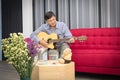 Retirement seniors sitting on a sofa playing guitar happily in the living room