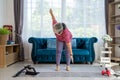 Retirement woman doing exercise with Revolved triangle pose at home