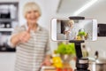 Retirement woman using modern smartphone, recording video blog