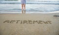 Retirement written on sand by sea at beach. Royalty Free Stock Photo