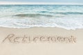 Retirement written on sand by sea Royalty Free Stock Photo