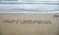 Retirement written on sand by sea at beach. Royalty Free Stock Photo