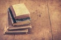 Retro aged books on oak wooden table. Vintage style filtered photo