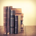 Retro aged books on oak wooden table. Vintage style filtered photo