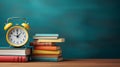 Retro alarm clock, books standing on a wooden table on a blurred green school board background, copy space, back to school