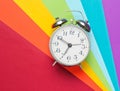 Retro alarm clock on a colored rainbow background