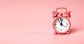 Retro alarm clock on coral colored banner with copy space for text