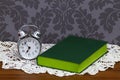 Retro alarm clock and green book Royalty Free Stock Photo