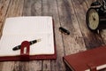 Retro alarm clock with memo book and luxury pen on wooden table