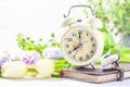 Retro alarm clock, notebook and spring flowers. Royalty Free Stock Photo