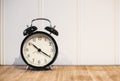 Retro alarm clock with 10 O`clock and twenty minuet, on wooden table and white background with copy space