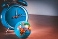 Retro alarm clock with a small world globe ball symbolizing Earth hour Royalty Free Stock Photo