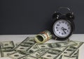 Retro alarm clock with stack dollars wooden table