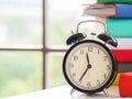 Retro Alarm clock on text books near the window, sunny day in the home office