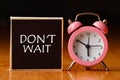 Retro alarm clock and the text `don`t wait `. Royalty Free Stock Photo