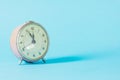Retro alarm-clock time on blue pastel background. Royalty Free Stock Photo