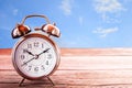 Retro alarm clock on a wooden table with blur green bokeh backgr Royalty Free Stock Photo