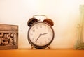 Retro alarm clock on wooden ton the shelf, vintage style