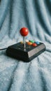 Retro arcade joystick with colorful buttons on a soft blue textured background Royalty Free Stock Photo