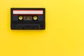 Retro audio tape cassette from 80s and 90s isolated on yellow background. Old technology concept. Flat lay, top view Royalty Free Stock Photo