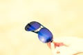 Retro aviator sunglasses model hold by hand in a summer day closeup . Selective focus