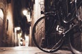 Retro bicycle in the night old city on background bokeh light flare in night architecture, vintage bike in evening street Royalty Free Stock Photo