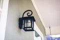 Retro black metal iron outdoor light lamp lantern hung on the exterior front entrance of a house home Royalty Free Stock Photo