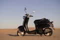 The Retro scooter at sunset in the golden sand of the Namib Desert