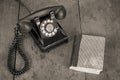 Retro black telephone and books on old oak wooden table. Vintage style sepia photo Royalty Free Stock Photo