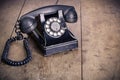 Retro black telephone on old oak wooden table. Vintage style photo