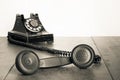 Retro black telephone on old oak wooden table. Vintage style sepia photo Royalty Free Stock Photo