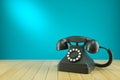 Retro black telephone on wooden table.