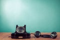 Retro black telephone on wooden table in front mint blue background. Vintage style photo