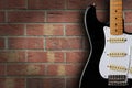 Retro black and white electric guitar on brick background with copy space Royalty Free Stock Photo