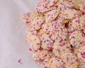 Retro British corner shop favourites. White chocolate with rainbow sprinkles on top. with white copy space