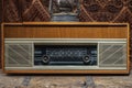 Retro broadcast radio receiver with blue eye light on wooden table circa 1950 front retro wall background. Listen music