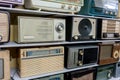 Retro broadcast radio receivers on wooden shelf against yellow background