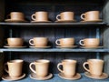 Retro Brown Clay Cups for Hot Coffee or Tea in Row on Shelf