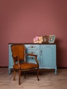 Retro brown leather armchair near blue dresser