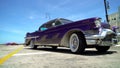 Retro Cadillac on background of sky. Actio. Luxurious retro Cadillac in purple color and resplendent appearance on