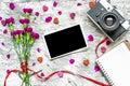 Retro camera and blank photo frame with purple carnation flowers Royalty Free Stock Photo