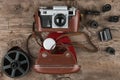 Retro camera in a brown leather case lies on a wooden table. Top view Royalty Free Stock Photo